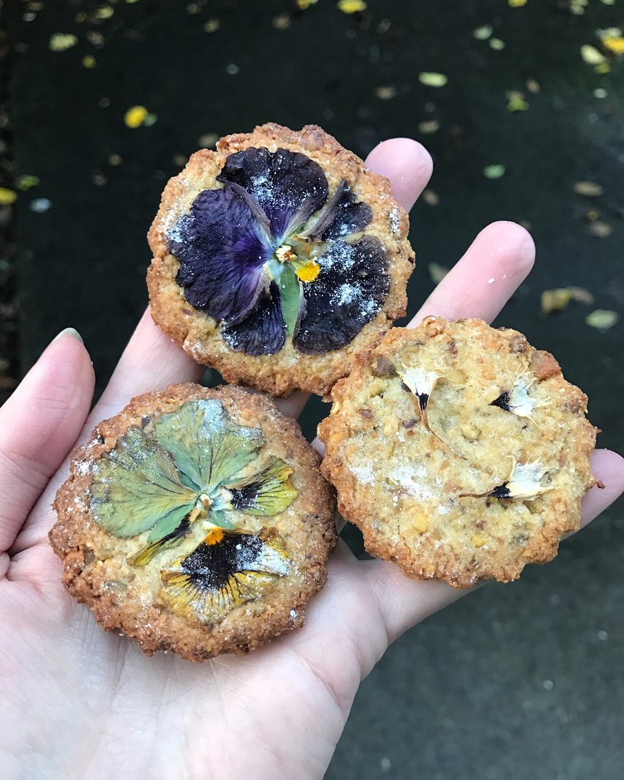Amy's hand holding flower-pressed gluten-free cookies